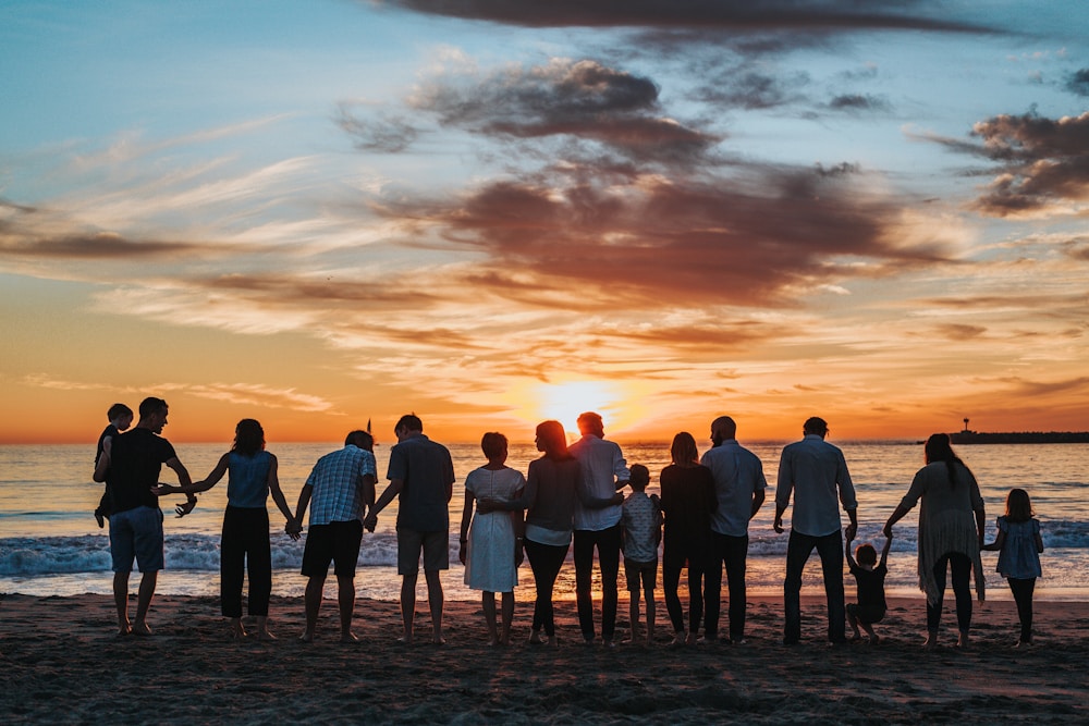 Family members together on the beach at sunset